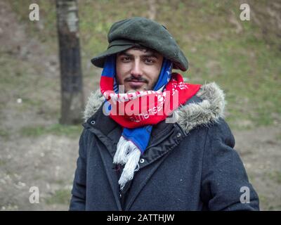 11. Dezember 2019 in Sarajevo, Bosnien und Herzegowina: Junger Mann lächelt im Flüchtlingslager Usivak in der Nähe von Sarajevo vor der Kamera.In Bosnien und Herzegowina versuchen rund 8000 Flüchtlinge und Migranten, einen Weg zu finden, wie man die Grenze zu Kroatien überquert und weiter in die westeuropäischen Länder kommt. Einige von ihnen leben in überfüllten Flüchtlingslagern, einige von ihnen bedrängen verlassene Gebäude oder schlafen einfach auf den Straßen. Viele von ihnen berichten, dass, wenn sie von der kroatischen Polizei an der Grenze gefangen werden, sie geschlagen werden, ihr Bargeld, Smartphones und Wertgegenstände gestohlen werden, Jacken und Schuhe verbrannt werden und die Stockfoto