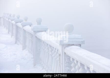 Frost- und eisbedeckte Baluster an einem Seeufer im Winter. Baikalsee, Listvyanka, Sibirien, Russland. Stockfoto