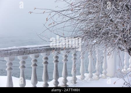 Frost- und eisbedeckte Baluster an einem Seeufer im Winter. Baikalsee, Listvyanka, Sibirien, Russland. Stockfoto