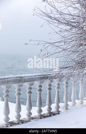 Frost- und eisbedeckte Baluster an einem Seeufer im Winter. Baikalsee, Listvyanka, Sibirien, Russland. Stockfoto