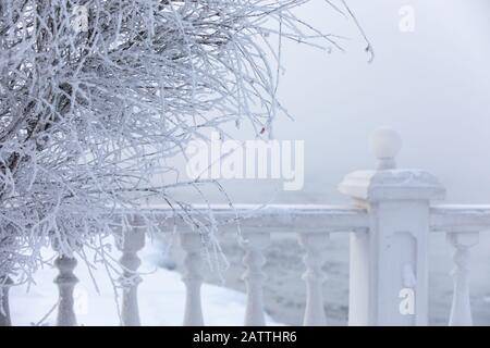 Frost- und eisbedeckte Baluster an einem Seeufer im Winter. Baikalsee, Listvyanka, Sibirien, Russland. Stockfoto