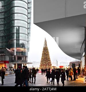 Weihnachtsbaum- und weihnachtsmarkt auf dem Gae Aulenti-Platz mit Unicredit Turm und Menschen - Mailand, Italien Stockfoto