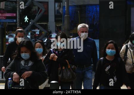 Hongkong, China. Februar 2020. Menschen durchqueren die Straßen von Central an einem Wochenende und tragen chirurgische Gesichtsmasken nach dem Ausbruch des Wuhan Corona-Virus. Anfang Februar wurden in Hongkong ein Todesfall und 18 Fälle von 2019-nCoV gemeldet (unter dem Verdacht der lokalen Übertragung). Credit: Sopa Images Limited/Alamy Live News Stockfoto