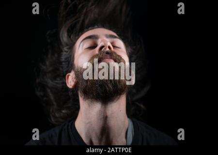 Hipster Teenager Mann Haare werfen, schwarz isoliert Hintergrund. Freiheitskonzept. Stockfoto