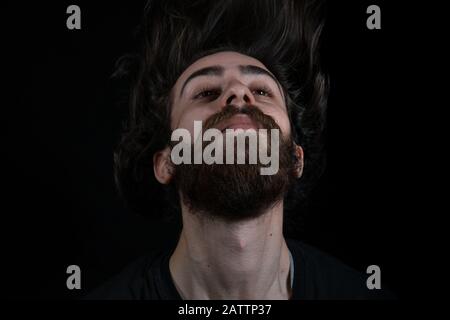 Hipster Teenager Mann Haare werfen, schwarz isoliert Hintergrund. Freiheitskonzept. Stockfoto