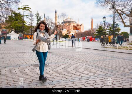 Wunderschönes junges Mädchen in modischer Kleidung mit Landkarte spaziert durch Istanbul, Türkei. Lifestyle-Konzept der Reisenden Frau. Stockfoto