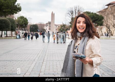 Schönes junges Mädchen in modischer Kleidung mit Kartenspaziergängen im Sultan-Ahmet-Park in Istanbul, Türkei.Traveler Woman Lifestyle-Konzept. Stockfoto