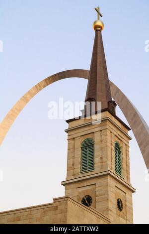 Ein Kirchturm der Basilika Saint-Louis, König von Frankreich, nannte auch die Alte Kathedrale mit dem Gateway-Bogen im Hintergrund, St. Louis, Missouri, USA. Stockfoto