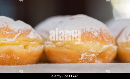 Seitenansicht (Nahaufnahme) eines österreichischen Krapfens. In nördlichen Teilen Deutschlands Berliner genannt. Ein Donut, besonders beliebt bei Karneval. Stockfoto