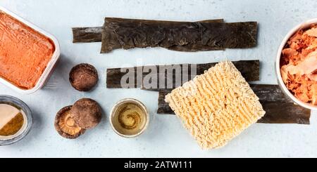 Ramen Zutaten Panorama. Getrocknete See-Gemüse-Kelp, Soba-Instantnudeln, rote Miso-Paste, Thunfisch-Flocken, Shiitake-Pilze, Sake, Mirin, Overhead-Schuss Stockfoto