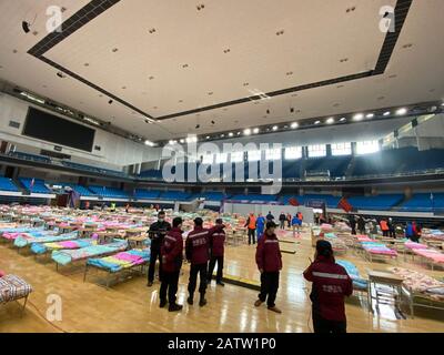 (200205) -- WUHAN, 5. Februar 2020 (Xinhua) -- Arbeiter sind damit beschäftigt, das Hongshan-Gymnasium in ein provisorisches Krankenhaus in Wuhan, der zentralchinesischen Provinz Hubei, 4. Februar 2020 umzuwandeln. Die chinesische Stadt Wuhan, das Epizentrum des Coronavirus-Ausbruchs, ist dabei, mehr provisorische Krankenhäuser zu schaffen, um die Überzahl der mit dem neuartigen Coronavirus infizierten Patienten zu bewältigen. Wuhan, die Hauptstadt der Provinz Hubei, hat beschlossen, 11 Veranstaltungsorte, darunter Turnhallen, Ausstellungszentren und Sportzentren, in provisorische Krankenhäuser umzuwandeln, die insgesamt über 10.000 Betten zur Verfügung stellen können. Das temporäre Stockfoto