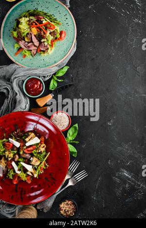 Salat mit Kalbfleisch, Fetakäse, Auberginen und Pilzen. In der Platte. Draufsicht. Freier Speicherplatz für Ihren Text. Rustikaler Stil. Stockfoto