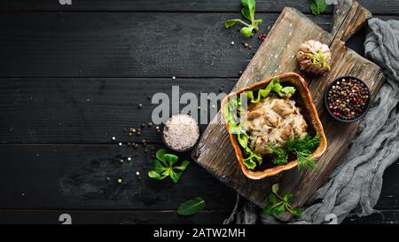 Champignons in Sauerrahmsauce mit Zwiebeln und Gewürzen. Auf rustikalem Hintergrund, Draufsicht, Banner. Stockfoto