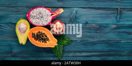 Drachenfrucht, Avocado, Papaya und Mangosteen. Tropische Früchte. Auf Holzgrund. Draufsicht. Kopierbereich. Stockfoto