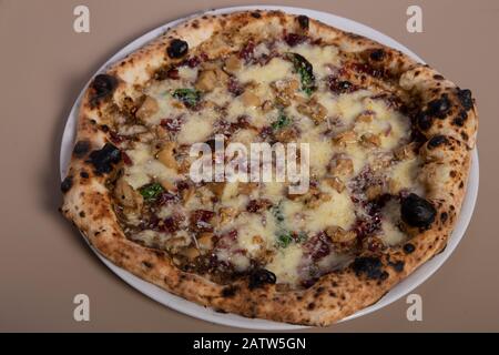 Neapolitanische Pizza mit Mozzarella, Wurst, schwarzem Trüffel, Basilikum, schwarzem Pfeffer und Parmesan. Draufsicht. Stockfoto