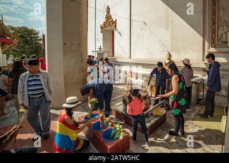 Ayutthaya, Thailand - 1. Januar 2016: Menschen, die lotosblumen kaufen und am ersten Tag des neuen Yea Inzenzstangen vor Wat Mongkhon Bophit anbieten Stockfoto