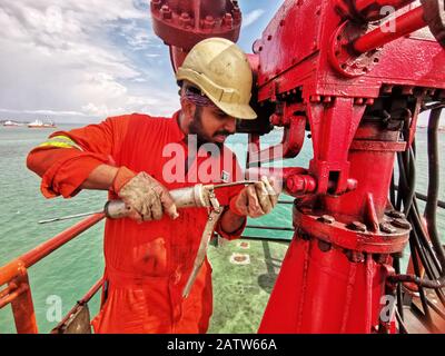 Die Crew der Marine plant Wartungen und Schmierfette auf dem FIFI-Brandbekämpfungsmonitor an Bord eines Schiffes Stockfoto