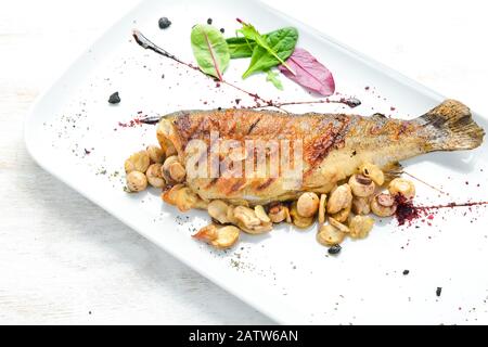 Gegrillte Forelle mit Pilzen auf einem Teller. Draufsicht. Freier Speicherplatz. Stockfoto