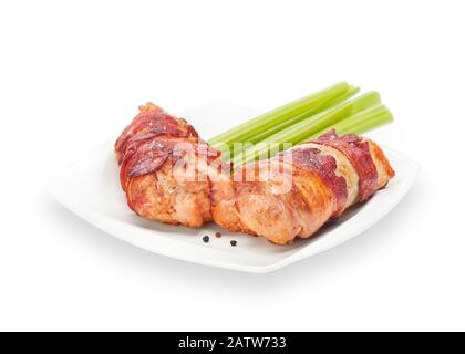 Bacon-Wrapped Meat Roll Crispy Chicken Boneless Drumstick auf einem weißen Teller mit Sellerie und Pfeffer. Gerolltes, Gefülltes Fleisch Aus Hühnerscheinen. Isoliert Stockfoto