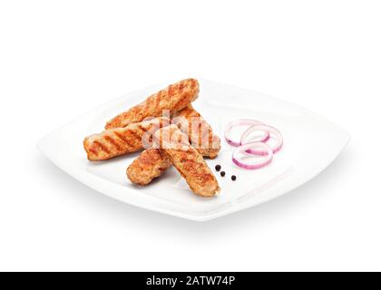 Heißer gebratener Knuspriger Hähnchenfleisch Cevapi gegrillt mit roter Zwiebel und Pfeffer auf einem weißen Teller. Grillfleisch Isoliert auf weißem Hintergrund Stockfoto