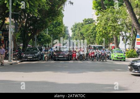 Hanoi, Vietnam - 22. August 2017: Straßenverkehr an Straßenampeln. Roller und Autos, die auf die Straße warten Stockfoto