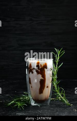 Kakao mit Karamell und Milch. Im Glas. Draufsicht. Auf schwarzem Hintergrund. Stockfoto