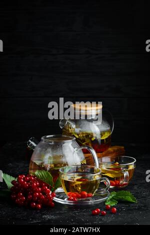 Tee aus Viburnum und Waldkräutern. Heiße Wintergetränke. Auf schwarzem Hintergrund. Draufsicht. Stockfoto