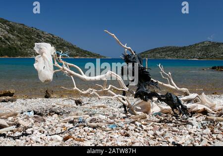 Treibholz mit Plastiktüten und anderem Müll am Kieselstrand, Ormos Planitis, Pelagonizi (Nisos Kyra Panagia), Sporaden, Griechenland Stockfoto