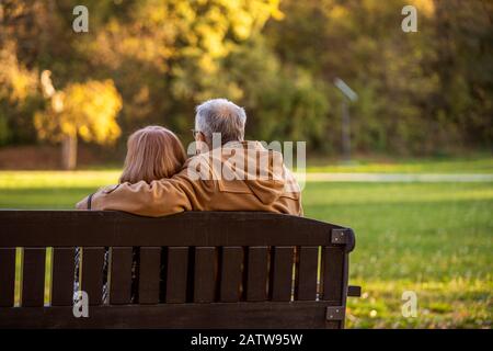 Romantische senior Paar sitzt auf der Bank im Park und genießen Sie den Herbst. Stockfoto