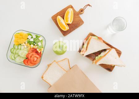 Mutter Cooking School Lunch Box Set, Vorbereitung gesunde Snacks - Käse Sandwich, Obst und Gemüse in Papiertüte. Stockfoto