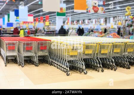 Viele leere Einkaufswagen im Supermarkt verschwimmen den Hintergrund. Viel Trolley im Geschäft Stockfoto