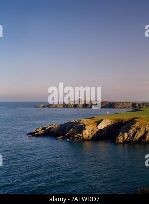 Insel Anglesey Coastal Path: Leuchtturm und Pilotstation auf Der Landzunge Point Lynas, die vom E-Ende der Bucht Porth Eilian in Wales in die Irische See ragt. Stockfoto