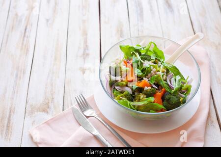 Warmer Gemüsesalat mit Kürbis, Perlgerste und Spinat auf altem, weiß-Holzhintergrund. Stockfoto