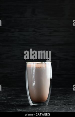 Kakao mit Karamell und Milch. Im Glas. Draufsicht. Auf schwarzem Hintergrund. Stockfoto
