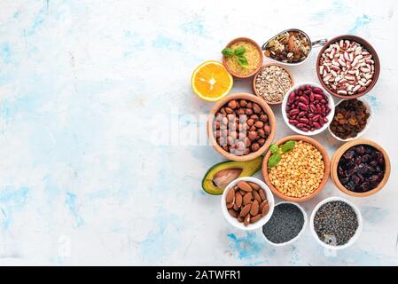 Gesunde Ernährung. Superfoods Nüsse, Beeren, Früchte und Hülsenfrüchte. Auf weißem Steingrund. Draufsicht. Freier Speicherplatz. Stockfoto