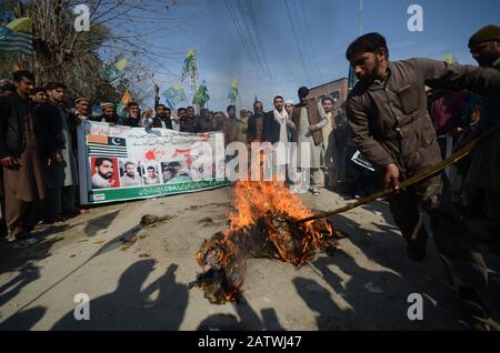 Peschawar, Pakistan. Februar 2020. Pakistanische Bevölkerung auf einer Kundgebung zum Solidaritätstag mit den Kaschmirs Mitgliedern des Albadar. Eine Gruppe von Kindern, die Pakistan und Azad Jammu und Kaschmir Flaggen winken, während sie sich versammeln, um den Solidaritätstag mit den Kaschmiris zu markieren. Indische Nationalflaggen und Effigie von Narendra Modi, die während des Protestes gequält wurden. (Foto von Hussain Ali/Pacific Press) Credit: Pacific Press Agency/Alamy Live News Stockfoto