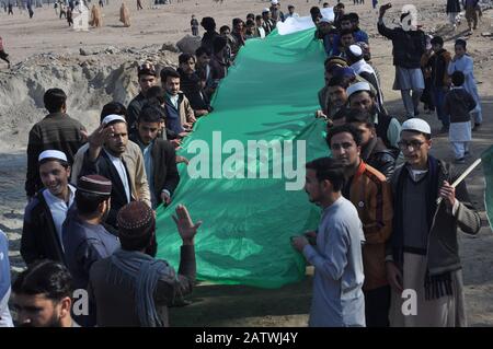 Peschawar, Pakistan. Februar 2020. Pakistanische Bevölkerung auf einer Kundgebung zum Solidaritätstag mit den Kaschmirs Mitgliedern des Albadar. Eine Gruppe von Kindern, die Pakistan und Azad Jammu und Kaschmir Flaggen winken, während sie sich versammeln, um den Solidaritätstag mit den Kaschmiris zu markieren. Indische Nationalflaggen und Effigie von Narendra Modi, die während des Protestes gequält wurden. (Foto von Hussain Ali/Pacific Press) Credit: Pacific Press Agency/Alamy Live News Stockfoto