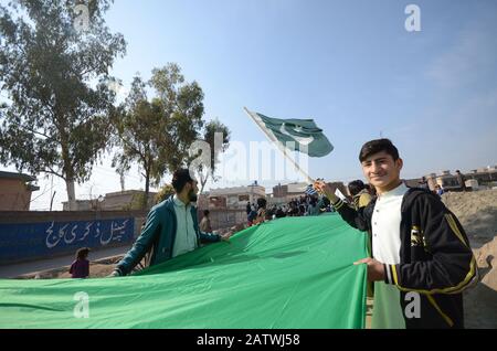 Peschawar, Pakistan. Februar 2020. Pakistanische Bevölkerung auf einer Kundgebung zum Solidaritätstag mit den Kaschmirs Mitgliedern des Albadar. Eine Gruppe von Kindern, die Pakistan und Azad Jammu und Kaschmir Flaggen winken, während sie sich versammeln, um den Solidaritätstag mit den Kaschmiris zu markieren. Indische Nationalflaggen und Effigie von Narendra Modi, die während des Protestes gequält wurden. (Foto von Hussain Ali/Pacific Press) Credit: Pacific Press Agency/Alamy Live News Stockfoto