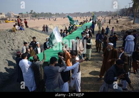 Peschawar, Pakistan. Februar 2020. Pakistanische Bevölkerung auf einer Kundgebung zum Solidaritätstag mit den Kaschmirs Mitgliedern des Albadar. Eine Gruppe von Kindern, die Pakistan und Azad Jammu und Kaschmir Flaggen winken, während sie sich versammeln, um den Solidaritätstag mit den Kaschmiris zu markieren. Indische Nationalflaggen und Effigie von Narendra Modi, die während des Protestes gequält wurden. (Foto von Hussain Ali/Pacific Press) Credit: Pacific Press Agency/Alamy Live News Stockfoto