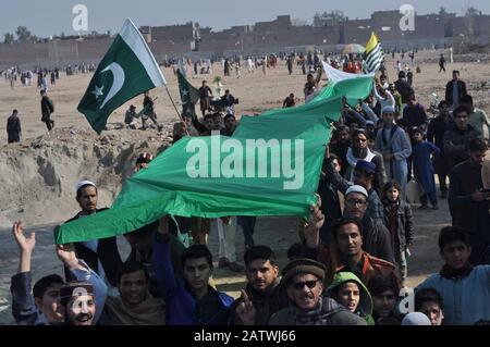 Peschawar, Pakistan. Februar 2020. Pakistanische Bevölkerung auf einer Kundgebung zum Solidaritätstag mit den Kaschmirs Mitgliedern des Albadar. Eine Gruppe von Kindern, die Pakistan und Azad Jammu und Kaschmir Flaggen winken, während sie sich versammeln, um den Solidaritätstag mit den Kaschmiris zu markieren. Indische Nationalflaggen und Effigie von Narendra Modi, die während des Protestes gequält wurden. (Foto von Hussain Ali/Pacific Press) Credit: Pacific Press Agency/Alamy Live News Stockfoto