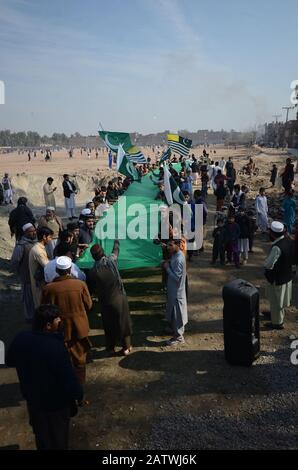 Peschawar, Pakistan. Februar 2020. Pakistanische Bevölkerung auf einer Kundgebung zum Solidaritätstag mit den Kaschmirs Mitgliedern des Albadar. Eine Gruppe von Kindern, die Pakistan und Azad Jammu und Kaschmir Flaggen winken, während sie sich versammeln, um den Solidaritätstag mit den Kaschmiris zu markieren. Indische Nationalflaggen und Effigie von Narendra Modi, die während des Protestes gequält wurden. (Foto von Hussain Ali/Pacific Press) Credit: Pacific Press Agency/Alamy Live News Stockfoto