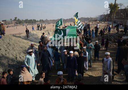 Peschawar, Pakistan. Februar 2020. Pakistanische Bevölkerung auf einer Kundgebung zum Solidaritätstag mit den Kaschmirs Mitgliedern des Albadar. Eine Gruppe von Kindern, die Pakistan und Azad Jammu und Kaschmir Flaggen winken, während sie sich versammeln, um den Solidaritätstag mit den Kaschmiris zu markieren. Indische Nationalflaggen und Effigie von Narendra Modi, die während des Protestes gequält wurden. (Foto von Hussain Ali/Pacific Press) Credit: Pacific Press Agency/Alamy Live News Stockfoto