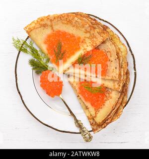 Pfannkuchen mit roter Kaviar auf einem Teller. Auf einer hölzernen Hintergrund. Ansicht von oben. Freier Platz für Text. Stockfoto