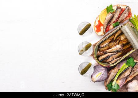 Wodka und ein Set Sandwiches mit Spraten und Kaviar, Zwiebel und Petersilie auf Holzgrund. Draufsicht. Kopierbereich. Stockfoto