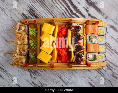 Großer Satz japanischer Rollen, die auf Holzbrett serviert werden Stockfoto