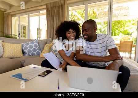 Glückliches junges Paar, das auf dem Sofa diskutiert Stockfoto