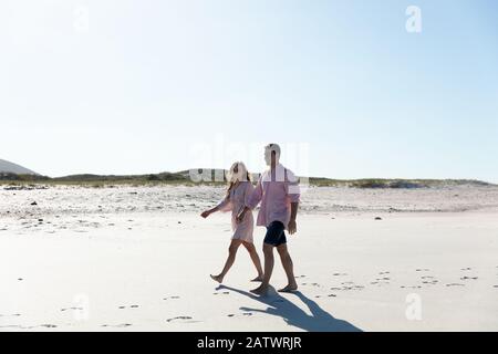 Seitenansicht des jungen Paares am Strand Stockfoto