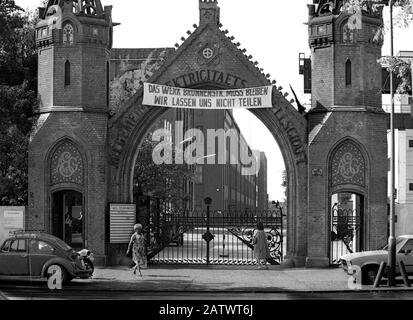 23. August 1982, Berlin: Protest gegen das historische AEG-Tor. Ein Banner mit der Aufschrift "Die Brunnenstr. Anlage muss bestehen bleiben - wir werden nicht geteilt" hängt am sogenannten offiziellen Tor der Elektrogruppe Allgemeine Elektrizitätsgesellschaft (AEG) in der Brunnenstraße. (Bestmögliche Bildqualität) Foto: Paul Glaser / dpa-Zentralbild / ZB Stockfoto
