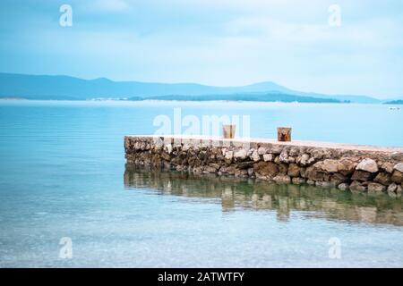 Altsteinpier an der adria, Stadt biograd. Hellblaues Meer und Himmel, Segelboote und Insel in der Ferne Stockfoto