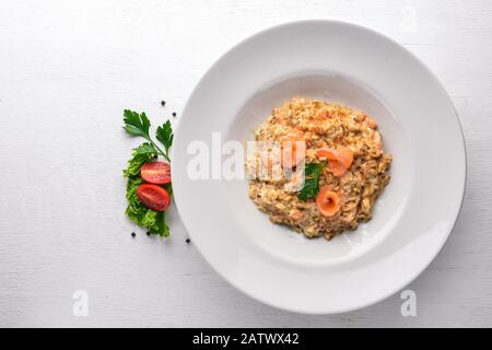 Risotto mit Lachs- und Sahnesauce. Auf Holzgrund. Draufsicht. Freier Speicherplatz. Stockfoto